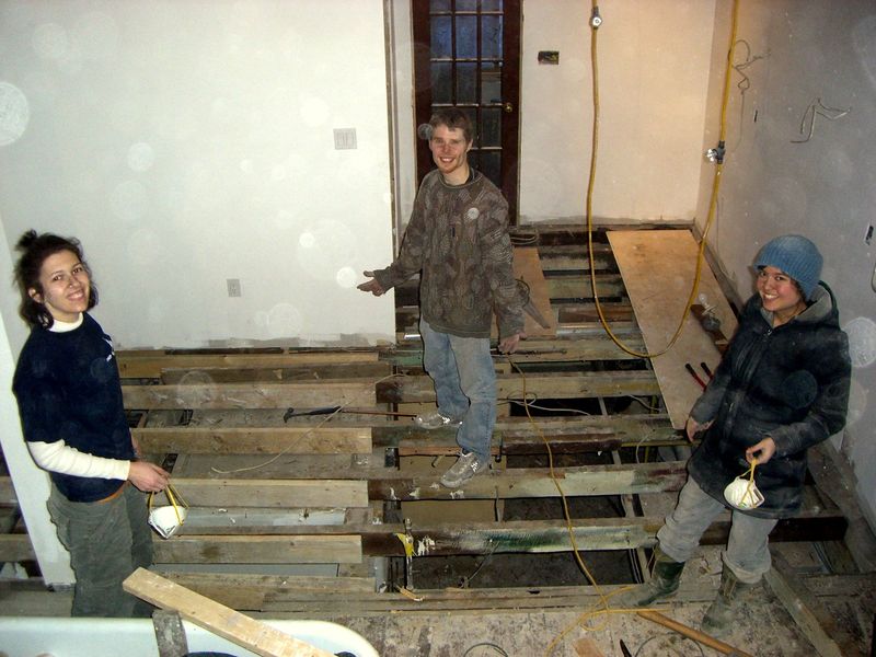 Early hands-on renovation work inside a stripped residential building.